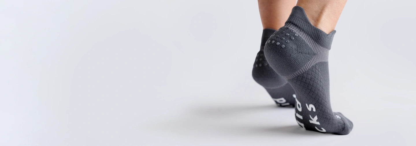 Gray adult grip socks showing heel grip and bottom traction