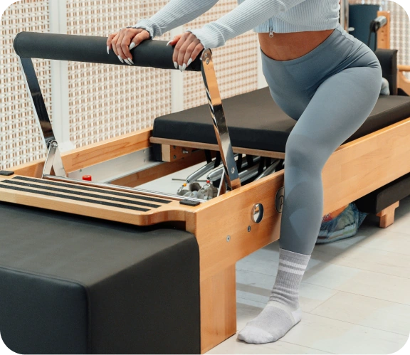 Adult wearing pale pink Squid Socks beside an exercise ball.