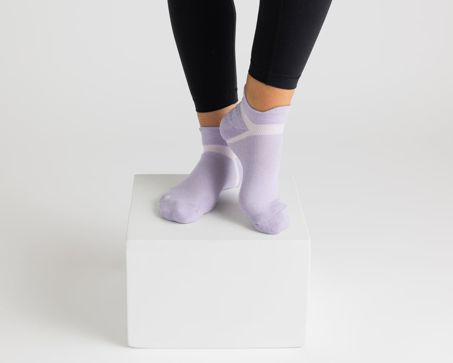 Lavender ankle grip socks worn with black leggings on a display block. By Squid Socks.