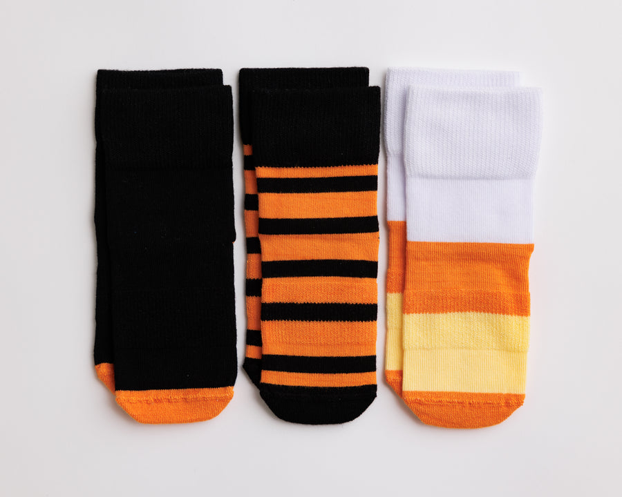 Candy Corn baby and kids grip socks in black, orange, yellow and white Halloween patterns.