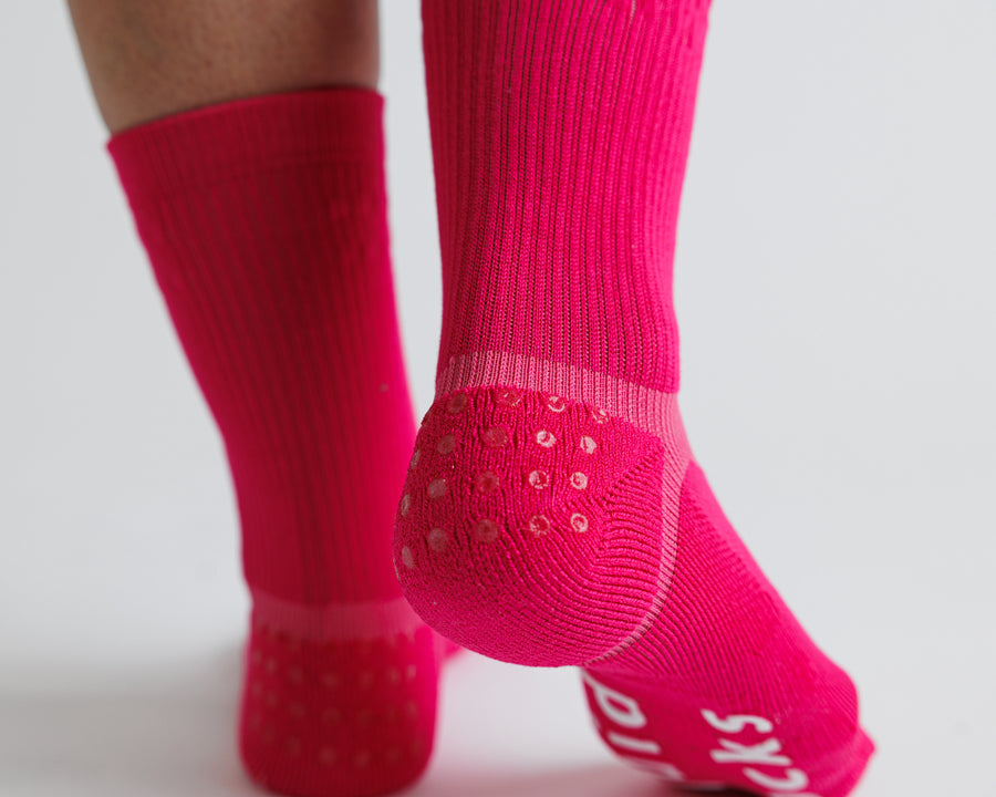 Rear close-up of Electric Pink crew grip socks showing heel grip dots. By Squid Socks.