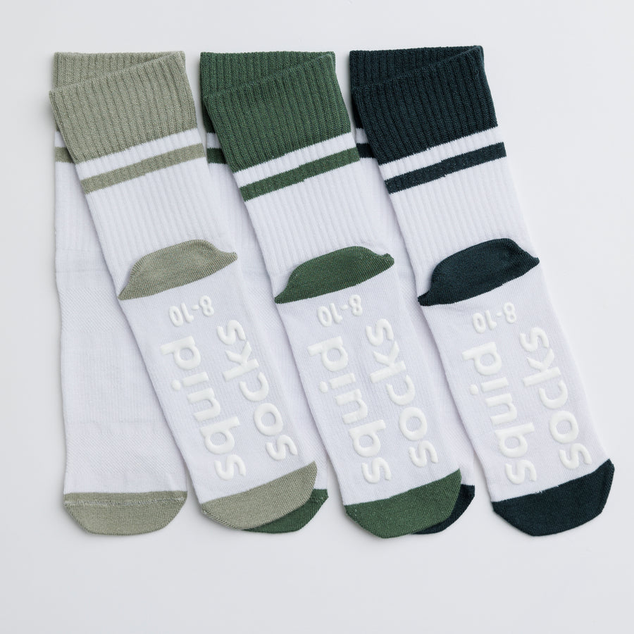 Cooper kids socks: white and green socks showing branded sole grips. Squid Socks, the brand seen on Shark Tank.