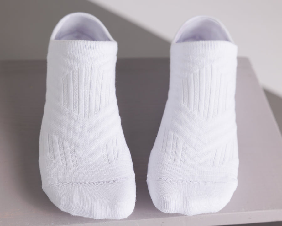 White no-show grip socks viewed from above, showing the knitted top panels. By Squid Socks.