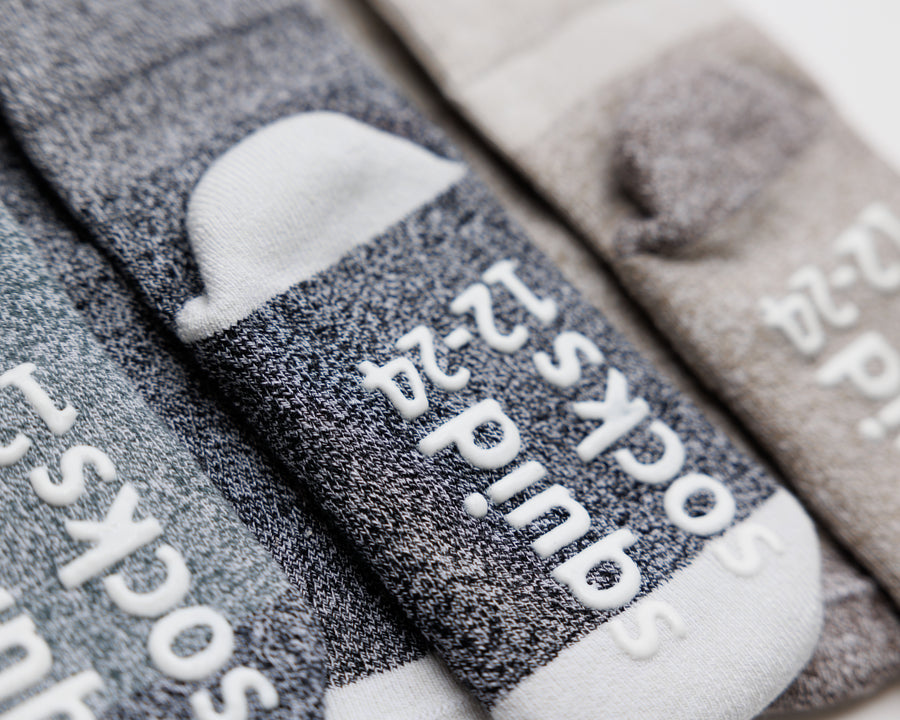 Caelan cotton crew socks: close-up of gray crew socks showing contrasting heels and sole grips. Squid Socks, the brand seen on Shark Tank.