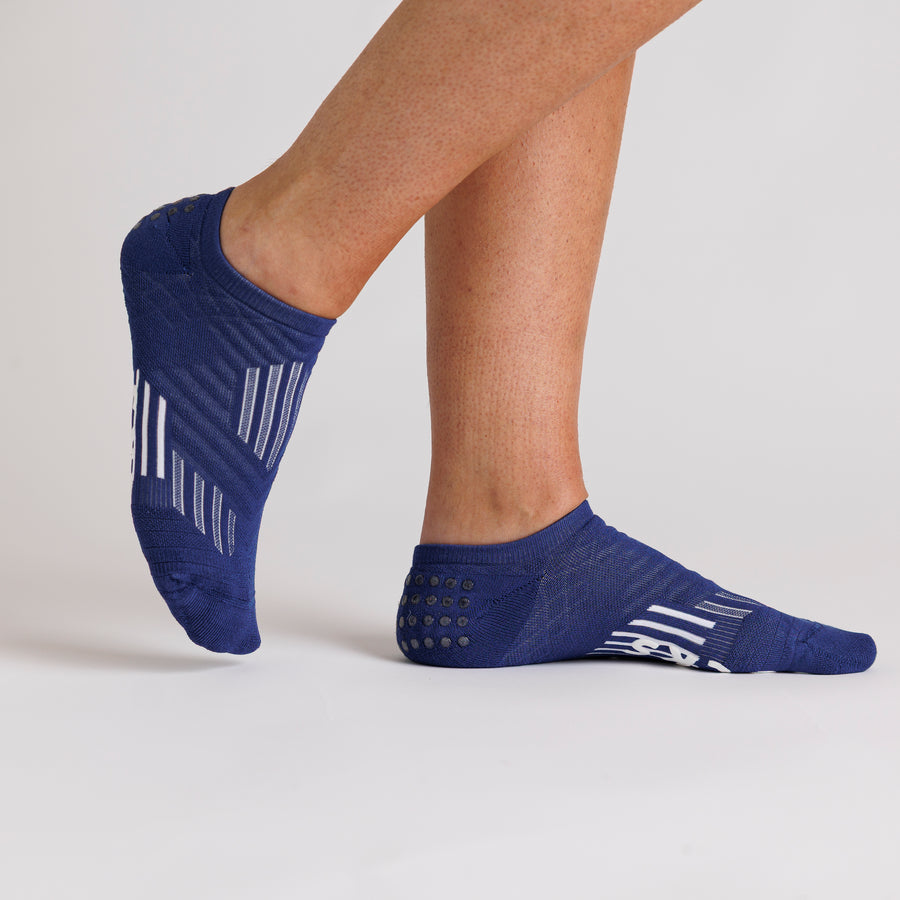 Navy no-show grip socks worn with one heel raised, showing side and top views. By Squid Socks.