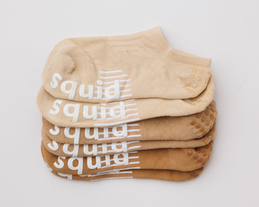 Caffeinated no-show grip socks in cream, tan, and brown, stacked to show all three colors. By Squid Socks.