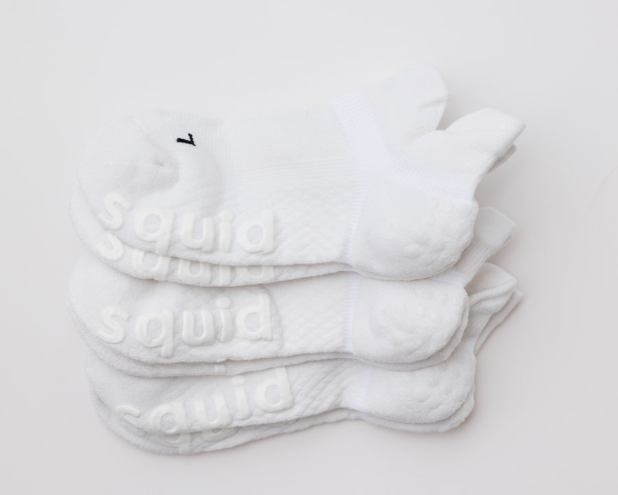 No-Brainer white ankle grip socks stacked with bottom grips and left and right markings visible. By Squid Socks.