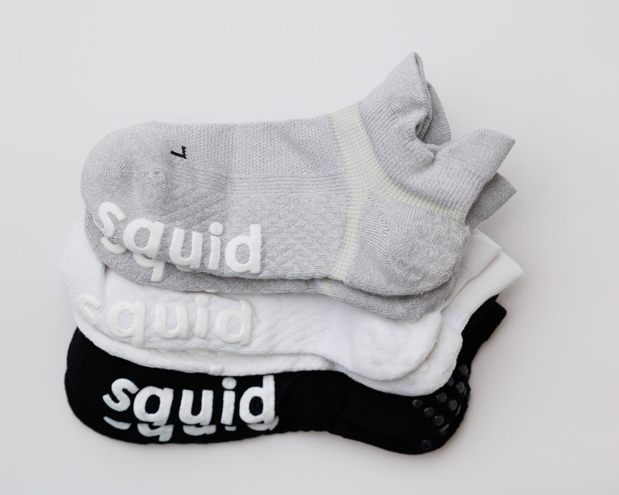 Back to Basics ankle grip socks in gray, white, and black, stacked to show all three colors. By Squid Socks.