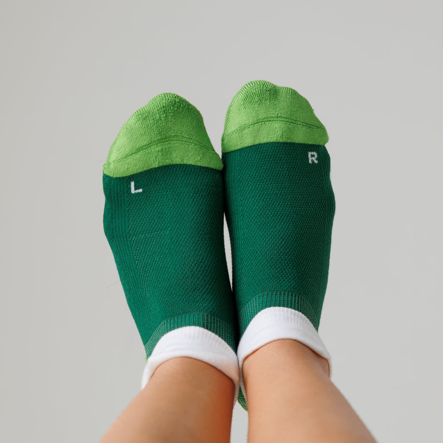 Green ankle pickleball grip socks viewed from above, showing lime toe panels and left and right markings. By Squid Socks.