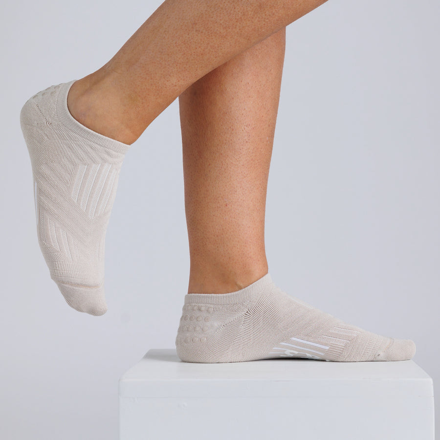 Cream no-show grip socks worn on a display block, showing side and top views. By Squid Socks.