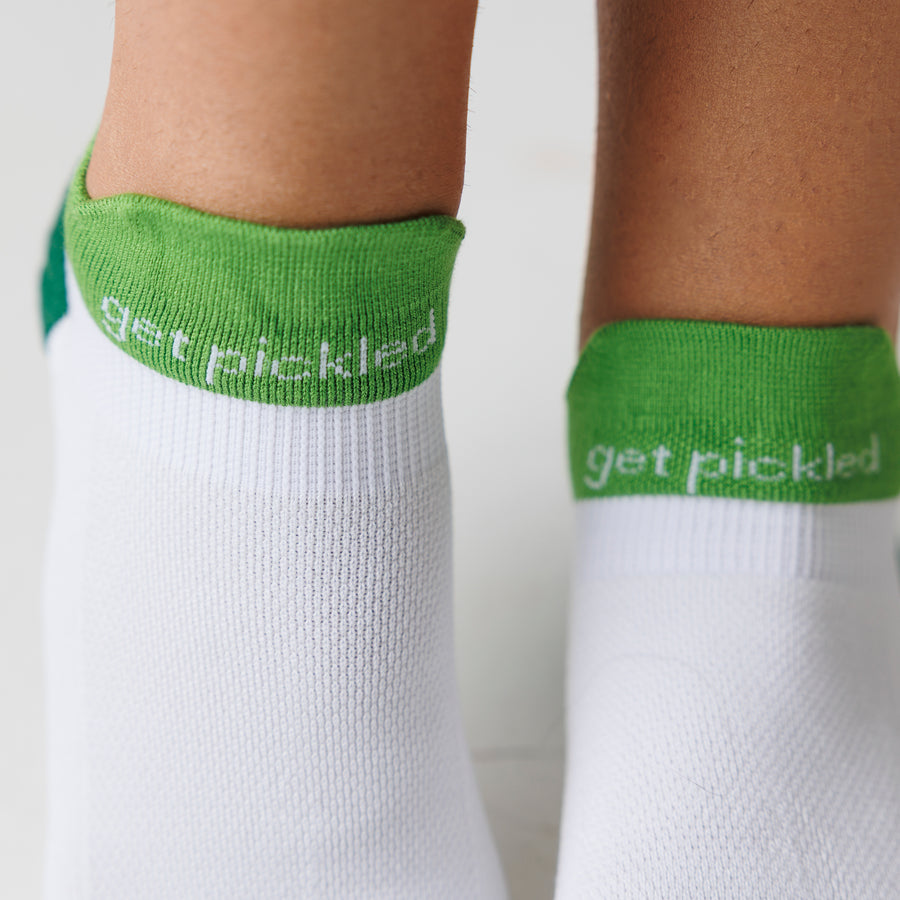 Close-up of white ankle pickleball socks with green cuffs and 'get pickled' lettering. By Squid Socks.