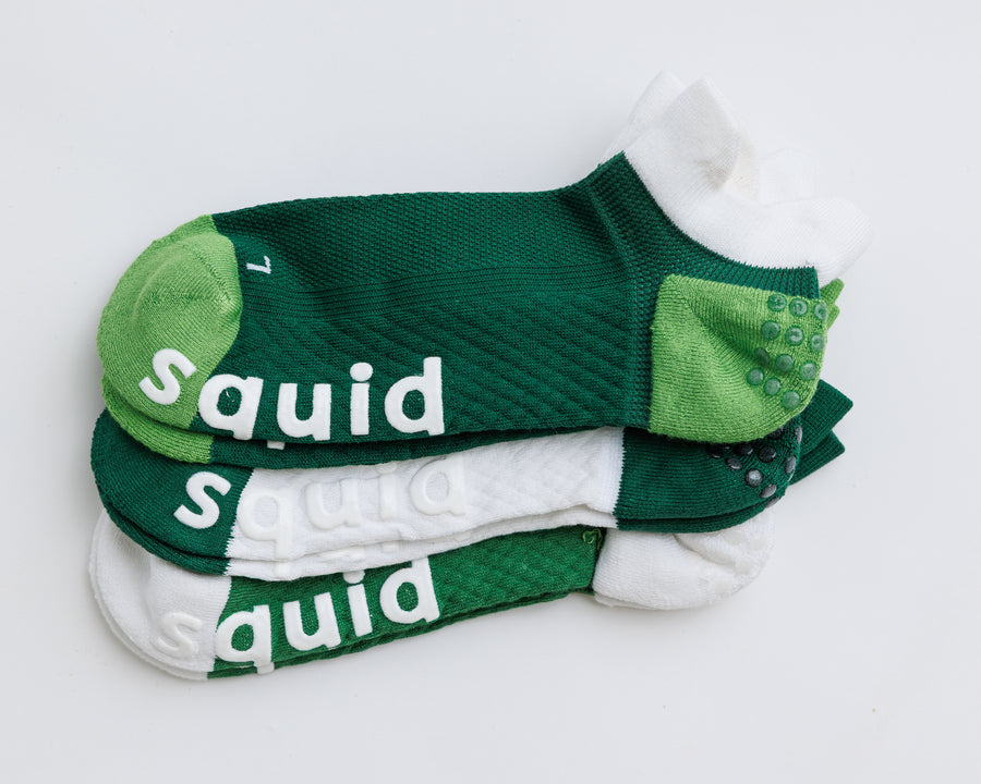 Pickle Pack ankle pickleball grip socks in green and white color combinations, stacked with bottom grips visible. By Squid Socks.