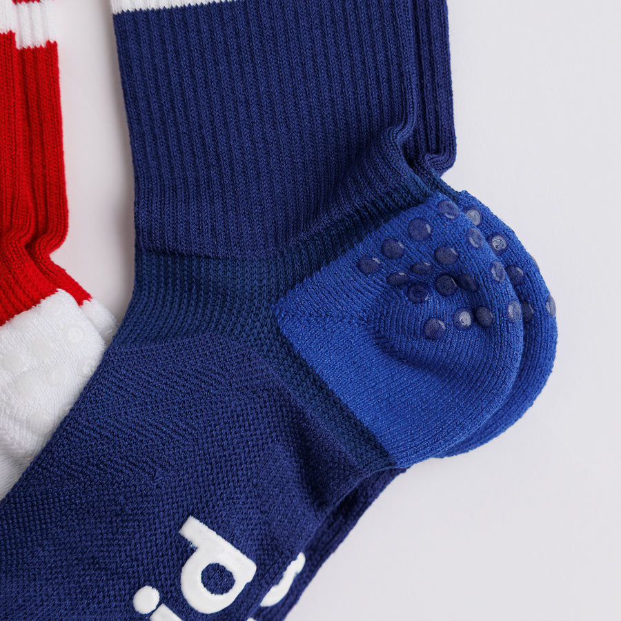 Close-up of All-American crew socks showing grip dots on a navy heel panel. By Squid Socks.