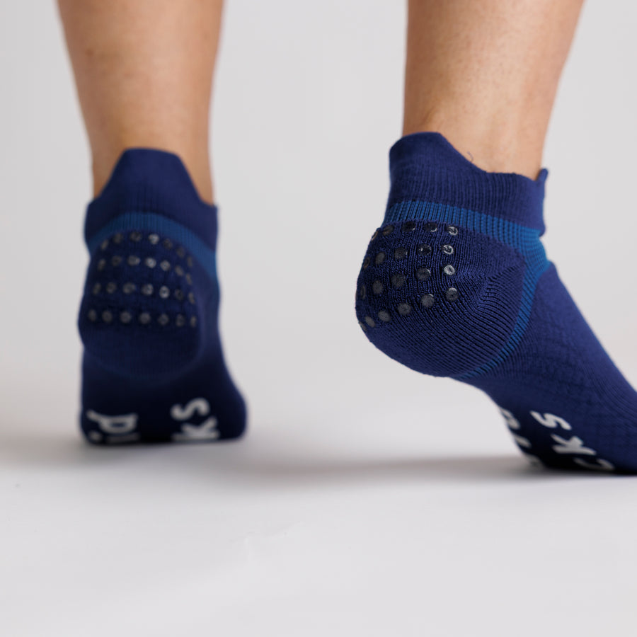 Navy ankle grip socks viewed from behind, showing the heel tabs and grip dots. By Squid Socks.