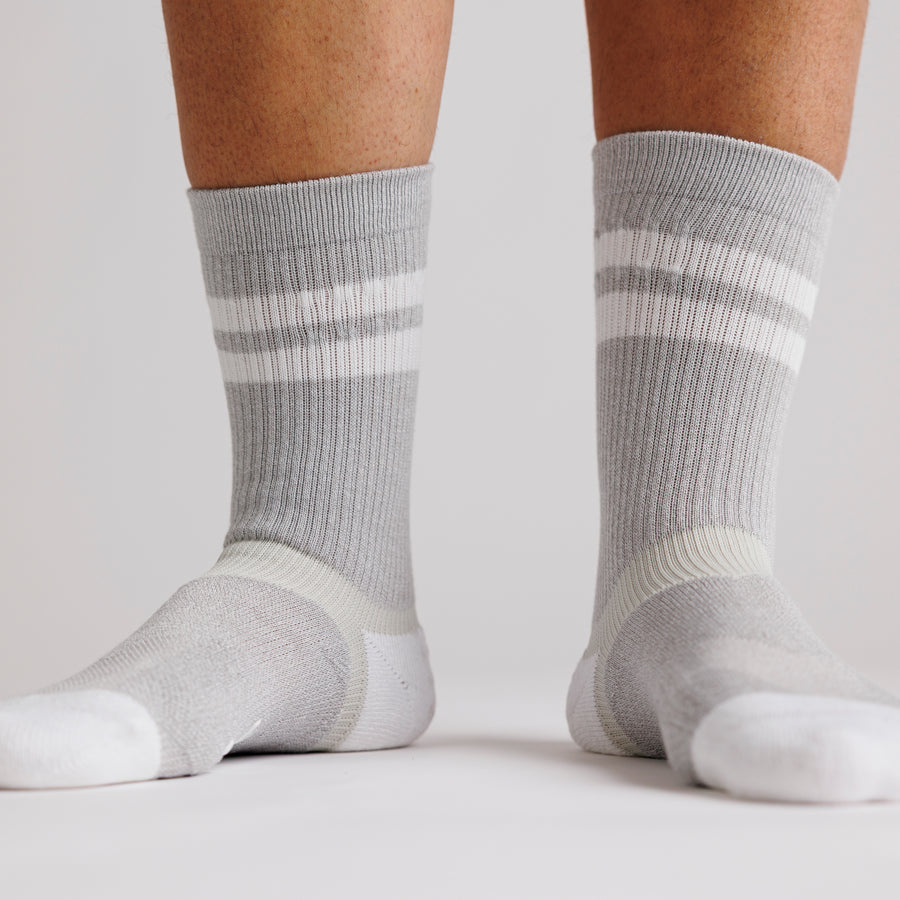 Gray Retro crew grip socks with white stripes worn on both feet. By Squid Socks.