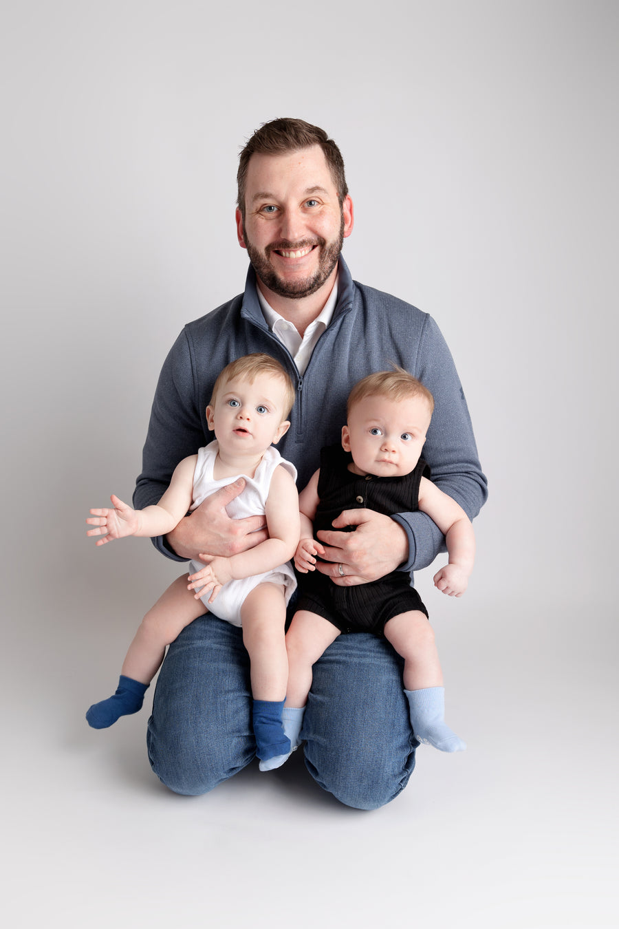 Chaney ankle socks: adult kneeling with two babies wearing blue ankle socks. Squid Socks, the brand seen on Shark Tank.