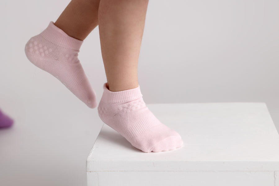 Ciara ankle socks: child standing on tiptoe in powder pink ankle socks. Squid Socks, the brand seen on Shark Tank.