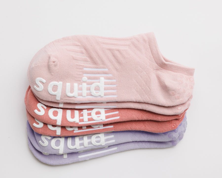 Perfectly Pastel no-show grip socks in light pink, coral, and lavender, stacked to show all three colors. By Squid Socks.