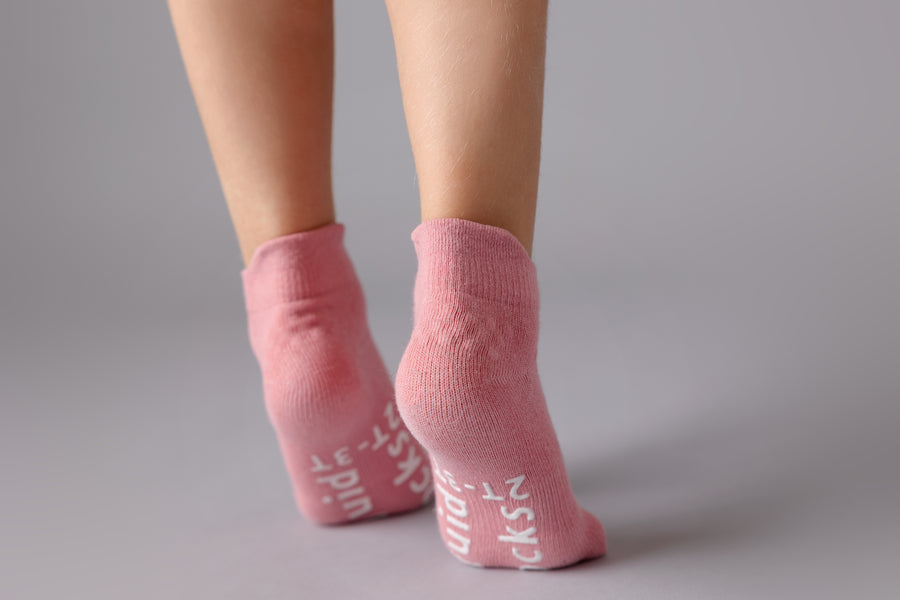 Ciara ankle socks: child standing on tiptoe showing rose sock soles. Squid Socks, the brand seen on Shark Tank.