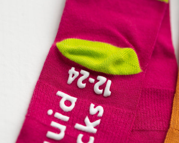 CeCe kids socks: pink sock showing green heel and branded sole grips. Squid Socks, the brand seen on Shark Tank.