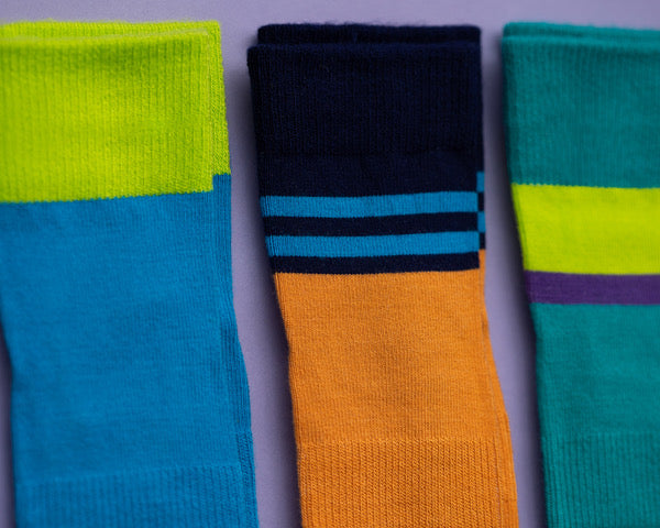 Clint kids socks: close-up of blue, orange and teal color-block designs. Squid Socks, the brand seen on Shark Tank.
