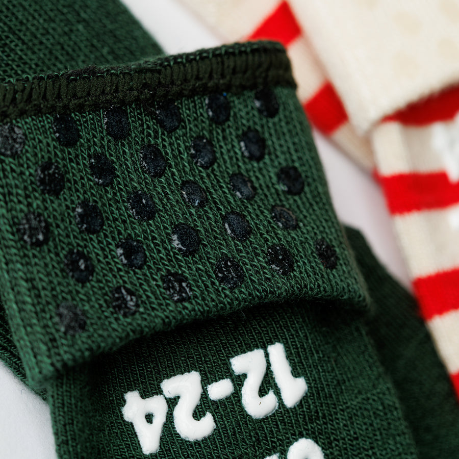 Close-up of silicone grip dots inside the cuff of a dark green Caroler sock.