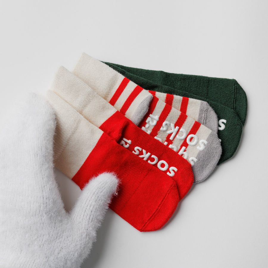 Close-up of Caroler socks showing red and cream stripes and silicone sole grips.