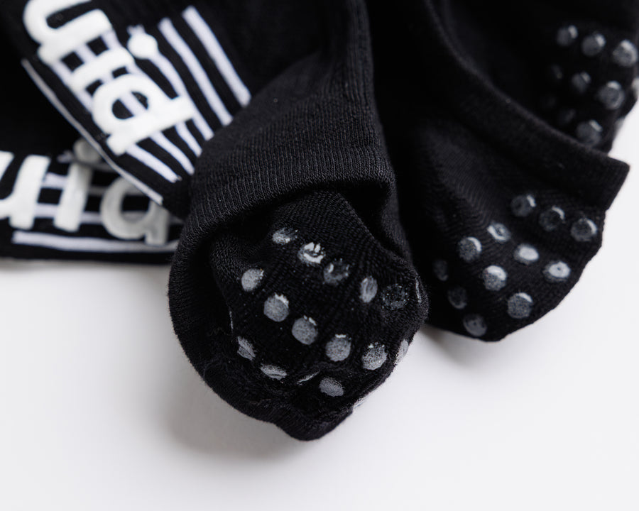 Close-up of black socks showing heel grip dots and white bottom grips. By Squid Socks.