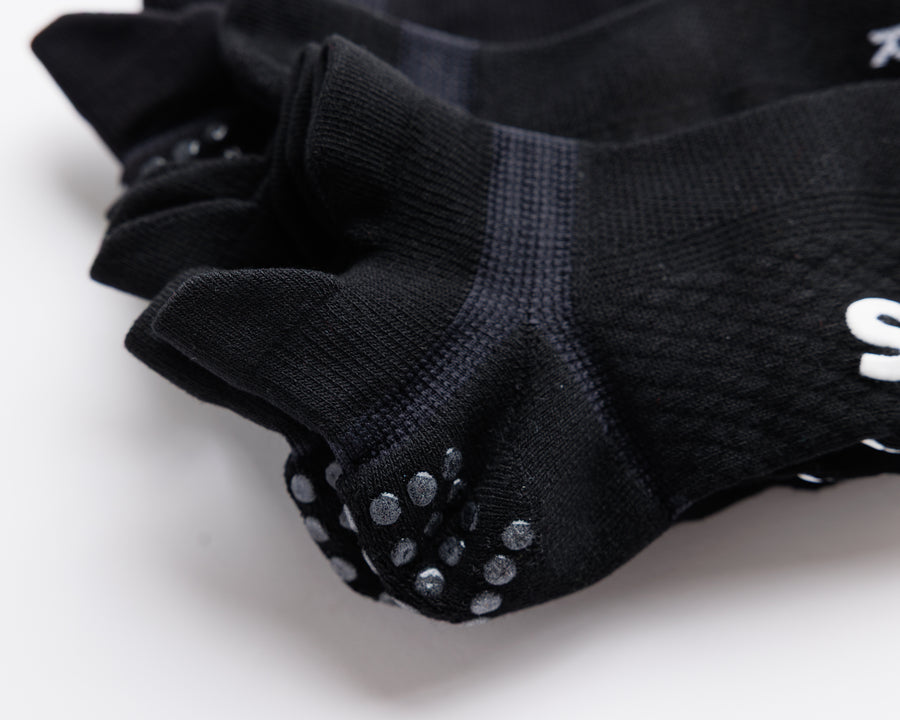Close-up of black ankle socks showing heel tabs and heel grip dots. By Squid Socks.