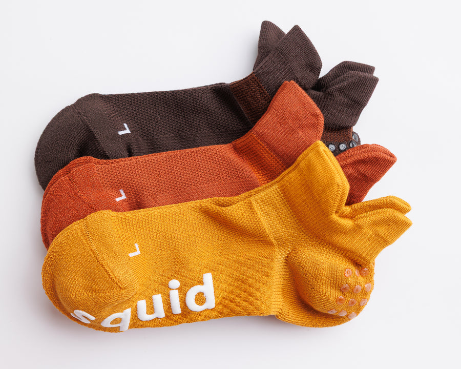 Fall Fanatic ankle grip socks in brown, rust orange, and mustard yellow, arranged together. By Squid Socks.