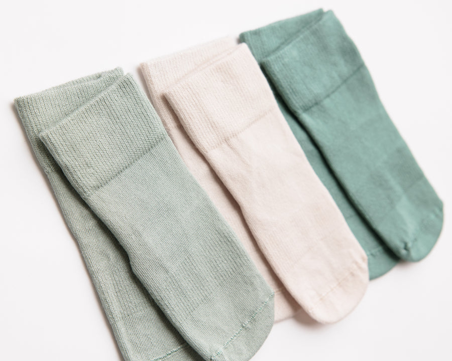 Coastal kids socks: muted green and stone socks laid flat. Squid Socks, the brand seen on Shark Tank.