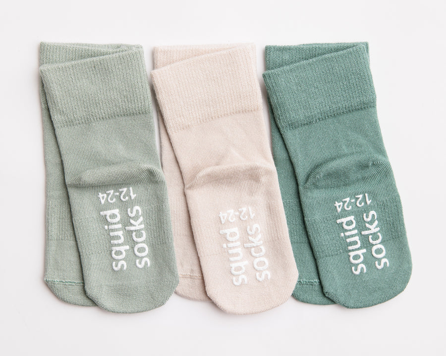 Coastal kids socks: muted green and stone socks showing branded soles. Squid Socks, the brand seen on Shark Tank.