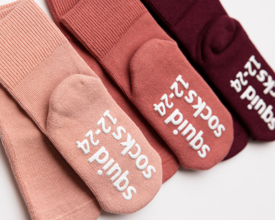 Courtney cotton crew socks: close-up of branded soles on pink and burgundy crew socks. Squid Socks, the brand seen on Shark Tank.