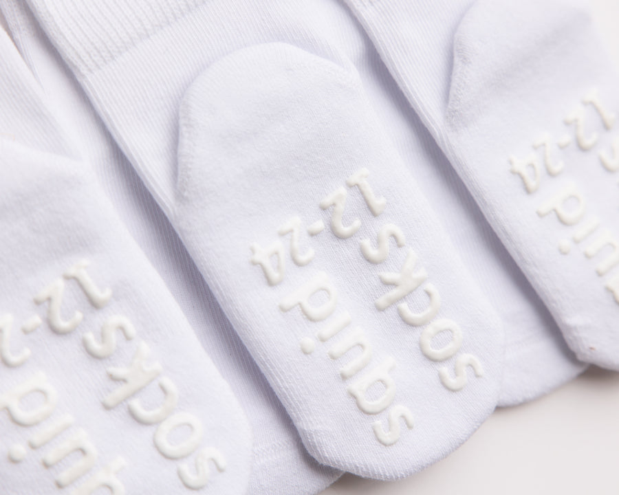 Dove cotton crew socks: close-up of branded sole grips on white crew socks. Squid Socks, the brand seen on Shark Tank.