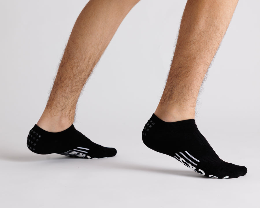 Black no-show grip socks worn with heels raised, showing side views. By Squid Socks.