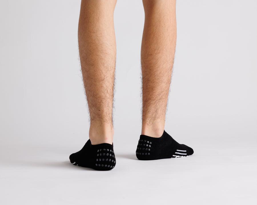 Black no-show grip socks viewed from behind, showing heel grip dots. By Squid Socks.