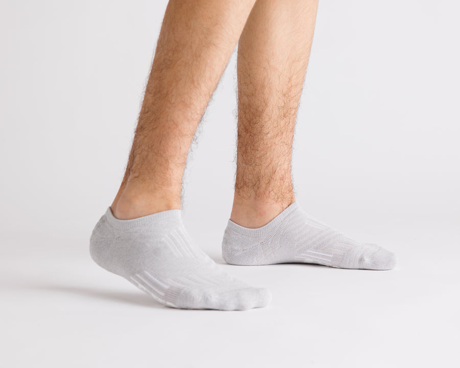 Gray no-show grip socks worn with heels raised, showing side views. By Squid Socks.