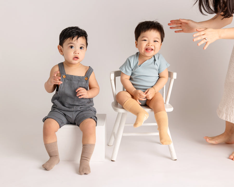 Caramel kids socks: two children seated in warm neutral socks. Squid Socks, the brand seen on Shark Tank.