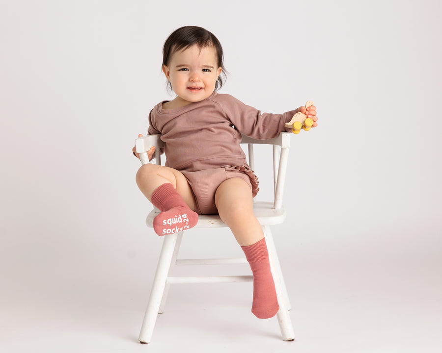 Courtney cotton crew socks: baby seated on a chair in dusty rose crew socks. Squid Socks, the brand seen on Shark Tank.