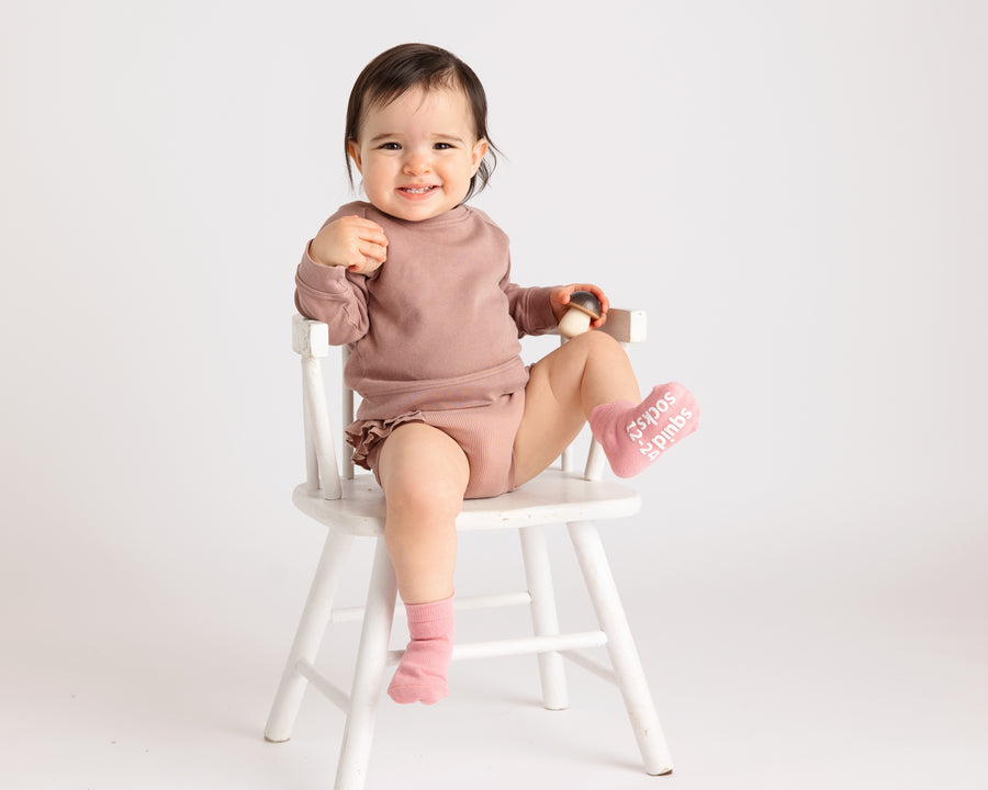 Ciara ankle socks: baby seated on a chair wearing rose ankle socks. Squid Socks, the brand seen on Shark Tank.