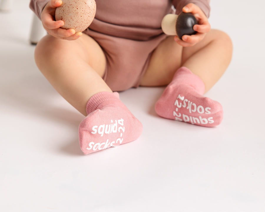 Ciara ankle socks: baby seated showing rose sock soles. Squid Socks, the brand seen on Shark Tank.