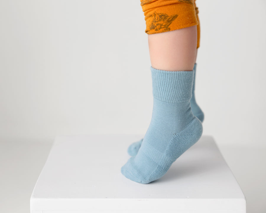 Camden cotton crew socks: child standing on a block in pale blue crew socks. Squid Socks, the brand seen on Shark Tank.