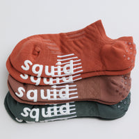 Earthbound no-show grip socks in terracotta, brown, and muted green, stacked to show all three colors. By Squid Socks.