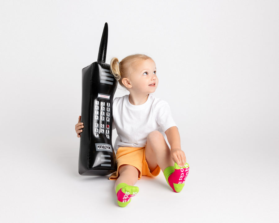 CeCe kids socks: child seated beside a toy phone wearing bright socks. Squid Socks, the brand seen on Shark Tank.