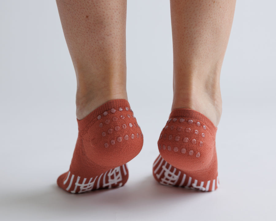 Terracotta no-show grip socks viewed from behind, showing heel and bottom grips. By Squid Socks.
