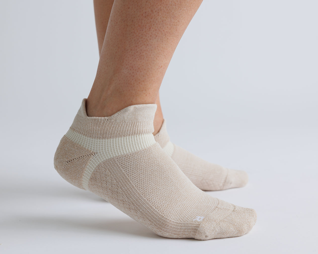 Beige ankle grip socks worn on both feet, showing side views. By Squid Socks.