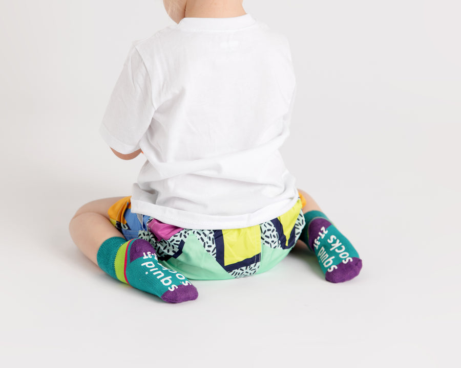 CeCe kids socks: child seated on the floor wearing teal socks. Squid Socks, the brand seen on Shark Tank.