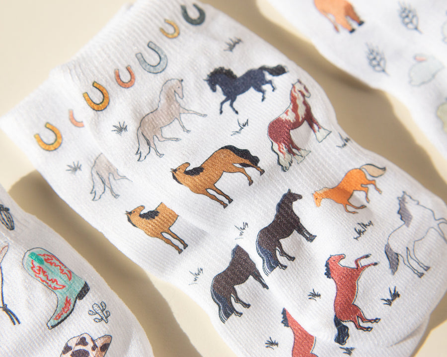 Cowboy kids socks: white socks with colorful horse prints. Squid Socks, the brand seen on Shark Tank.