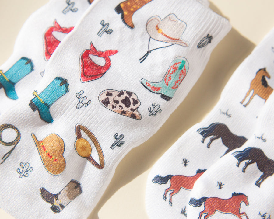 Cowboy kids socks: white socks with cowboy hats, boots and bandanas. Squid Socks, the brand seen on Shark Tank.