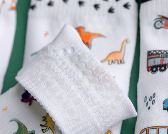 Cohen kids socks: close-up of cuff grip dots beside dinosaur prints. Squid Socks, the brand seen on Shark Tank.